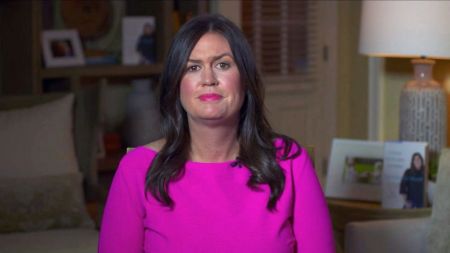 Sarah Sanders in a pink t-shirt speaking in an interview.